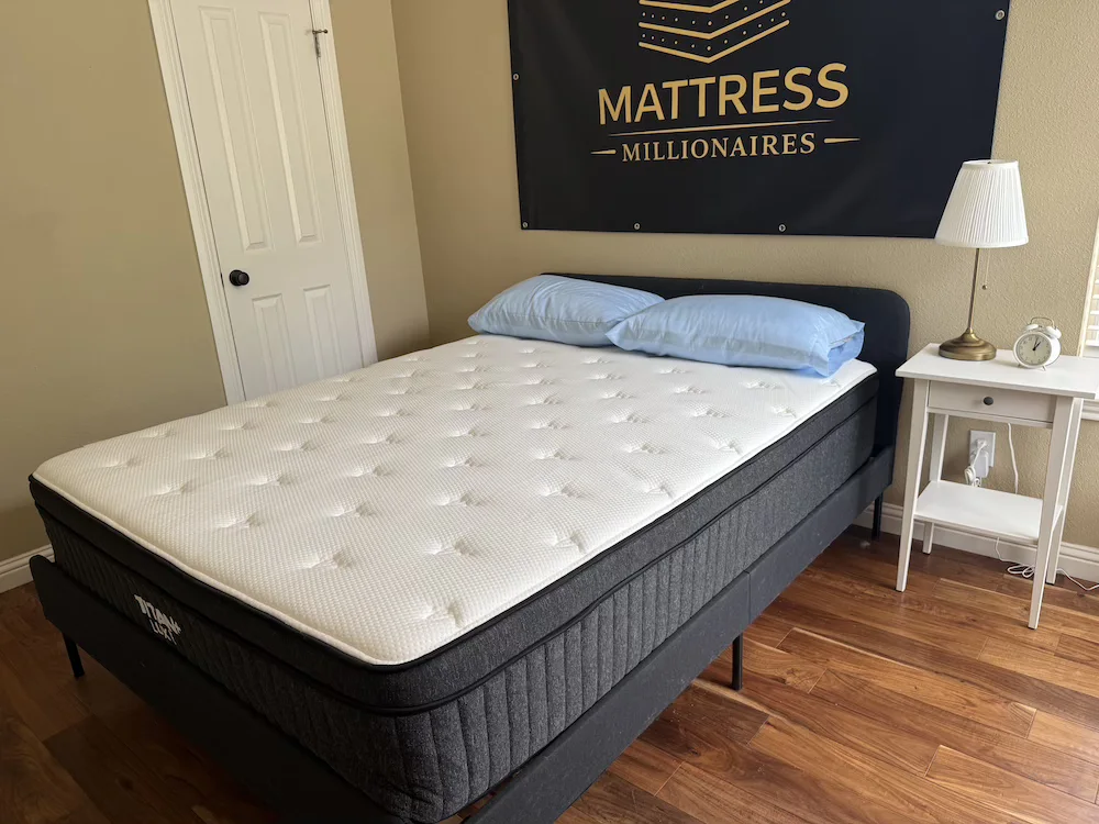 Titan Plus Luxe mattress on a bed frame in the Mattress Millionaires testing room.