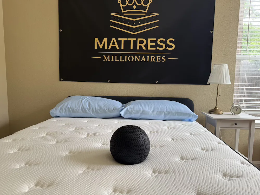 Black weighted ball resting on the quilted surface of a Titan Plus Luxe mattress