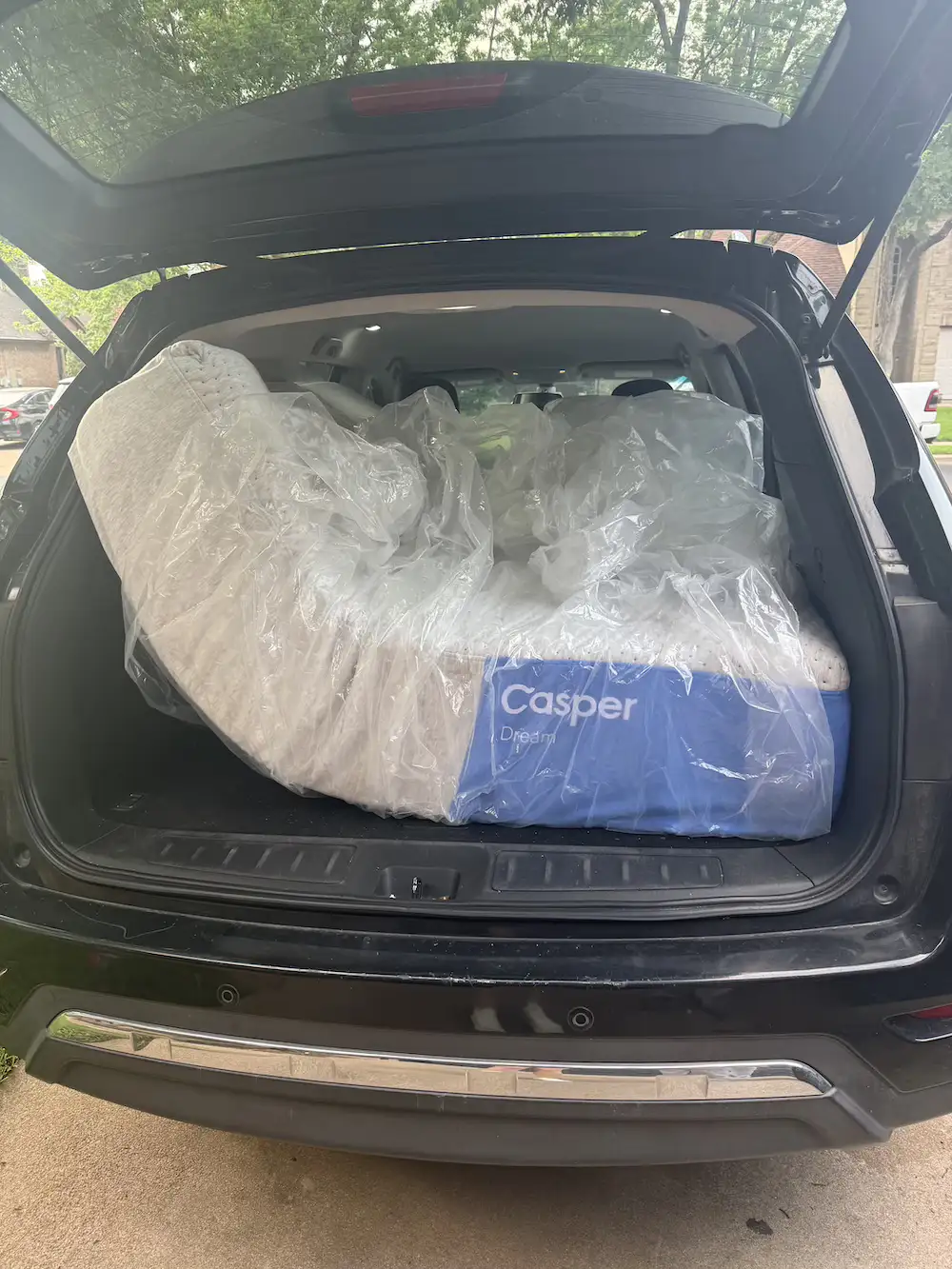 Casper Dream mattress wrapped in plastic and loaded into the back of an SUV for transportation