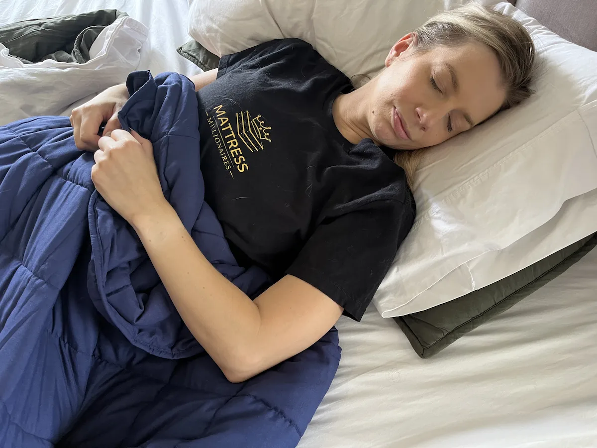 Sleeper under a weighted blanket experiencing warmth during sleep