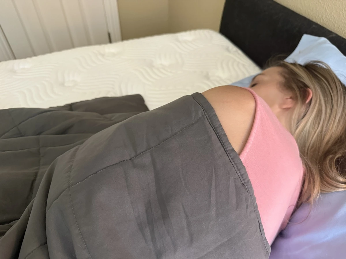 Close-up showing a weighted blanket resting evenly across a sleeper's body