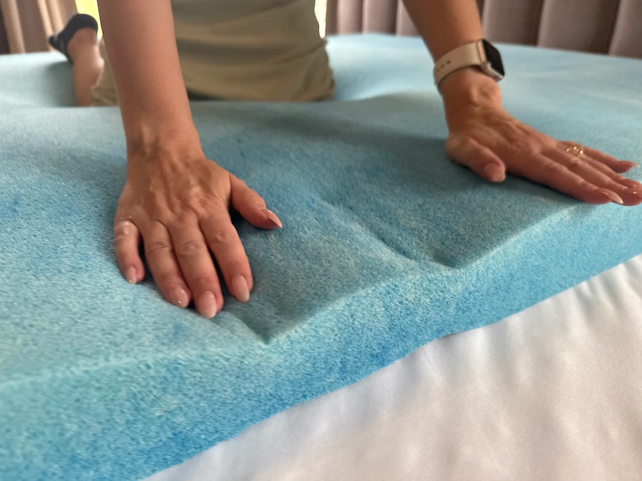An image of a woman pushing down on memory foam padding.