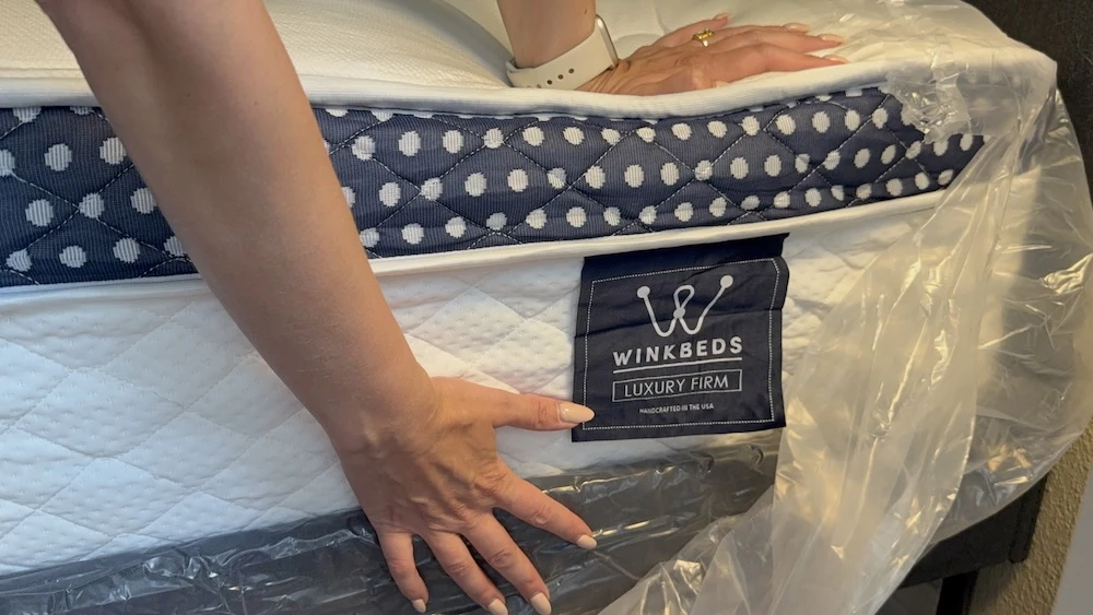 Close-up of WinkBed Luxury Firm mattress label during unboxing and setup