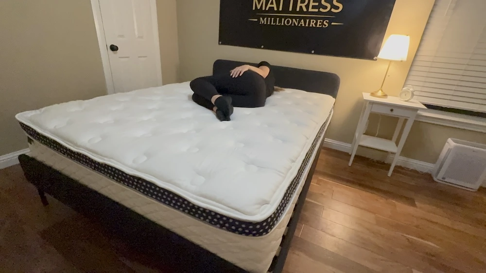 Tester side sleeping on the WinkBed Luxury Firm mattress during hands-on testing